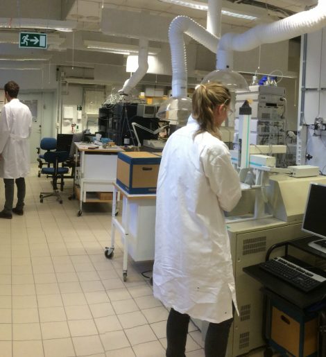 Backs of woman and male researcher in lab